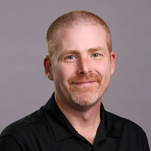 Archer Coppedge, a man in a black shirt smiling for the camera.