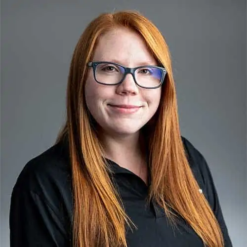 Hayley Martin, a woman with red hair wearing glasses and a black shirt.