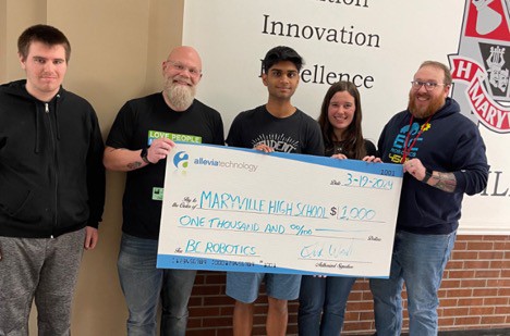 Group of people presenting a large ceremonial check to Maryville High School from BE Robotics to support STEM education.
