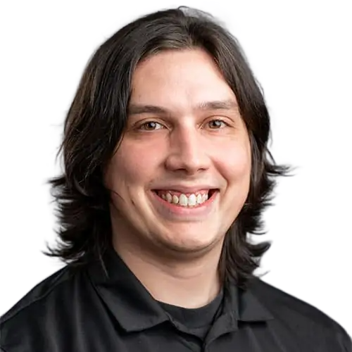 A smiling man with long hair wearing a black shirt.