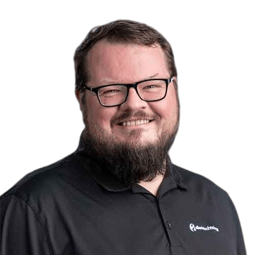 An IT expert with glasses and a beard smiling in front of a green background.