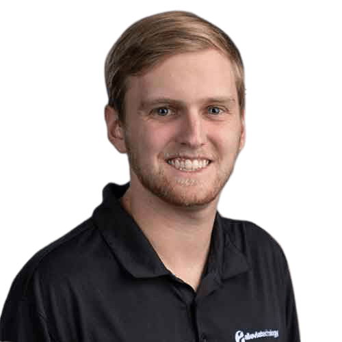 A man in a black shirt smiling for the camera, representing IT experts who manage and maintain your network.